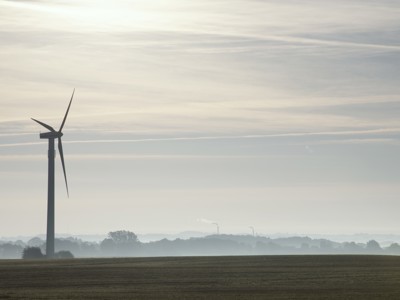 Vindmølle i dis og solnedgang